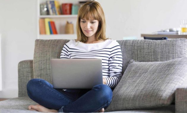 wanita dengan laptop duduk di sofa